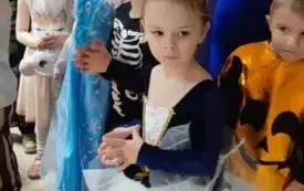dziewczynka w przebraniu baletnicy w tle inne dzieci w kolorowych strojach karnawałowych