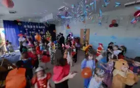 dzieci w przebraniach karnawałowych na sali udekorowanej balonami serpentynami