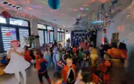 dzieci w przebraniach karnawałowych na sali udekorowanej balonami i serpentynami