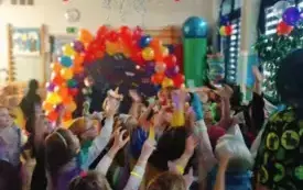 dzieci w przebraniach karnawałowych na sali udekorowanej balonami serpentynami