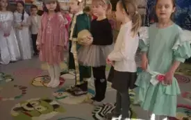 dzieci w przebraniach stoją na środku sali w tle inne dzieci