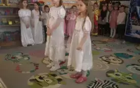dziewczynki w białych strojach na środku sali w tle inne dzieci