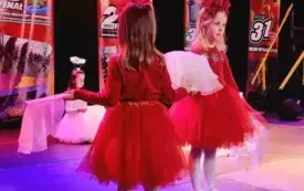 dwie dziewczynki w czerwonych strojach na scenie  w tle dekoracje wielkiej orkiestry świątecznej pomocy