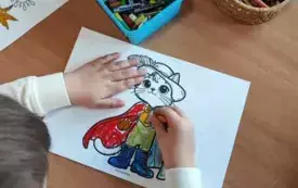 ręce dziecka kolorujące obrazek kota w butach