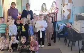 grupa dzieci wraz z nauczycielkami pozuje do zdjęcia z nimi panie z kotami na rękach