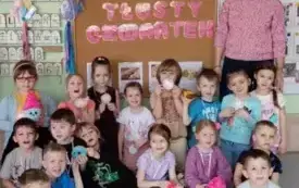 grupa dzieci wraz z panią nauczycielką pozują do zdjęcia przy dekoracji tłusty czwartek