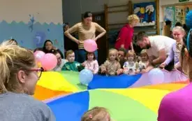 dzieci i dorośli dookoła chusty animacyjnej, na chuście balony