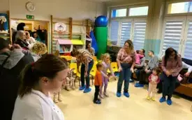 dorośli i dzieci stoją w kole