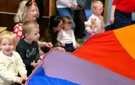 dzieci i panie trzymają kolorową chustę animacyjną