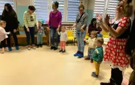 dorośli i dzieci stoją w kole
