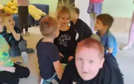 chłopcy siedza pod kolorową chustą animacyjną