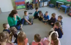 dzieci wraz z panią nauczycielką siedzą w kole