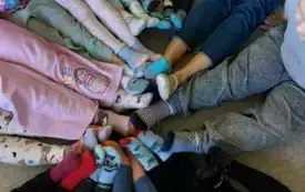 stopy dzieci w kolorowych skarpetkach dotykające się wewnątrz koła