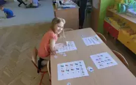 dziewczynka przy stoliku przed nią karty pracy z motywem skarpetek