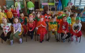 dzieci w kolorowych owocowo warzywnych przebraniach siedzą na krzesełkach