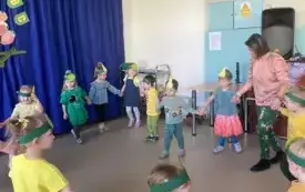 nauczycielka z dziećmi tańczą w kole