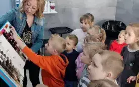 pani fryzjerka pokazuje dzieciom wzory kolor&oacute;w włos&oacute;w na palecie dzieci dotykają przyglądają się