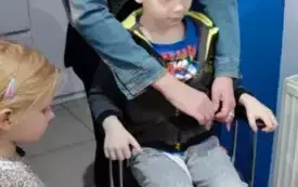 chłopiec siedzi na fotelu fryzjerskim za nim stoi pani fryzjerka