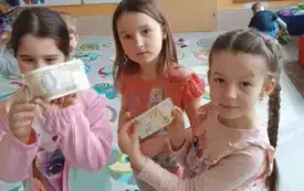 trzy dziewczynki stoją trzymają w dłoniach banknoty polskich złotych
