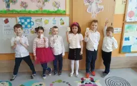 dzieci stoją w szeregu każdy trzyma literę