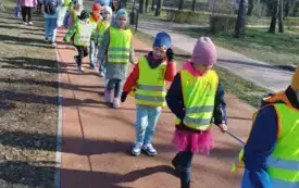 dzieci ubrane w kamizelki odblaskowe tworzą rząd na ścieżce rowerowej