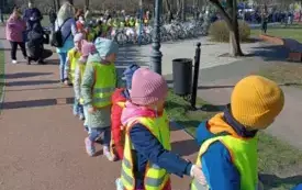 dzieci w kamizelkach odblaskowych ustawione w szeregu na ścieżce rowerowej