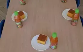 stolik na kt&oacute;rym ustawione są porcje ciasta marchewkowego i soki marchewkowe