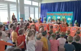 grupa dzieci na sali gimnastycznej część dzieci przebrana za marchewki z obu stron sali panie nauczycielki