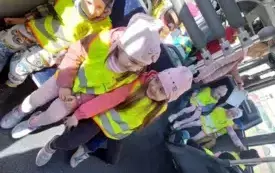 grupa dzieci w kamizelkach odblaskowych siedzi w autobusie