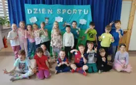 grupa dzieci w strojach sportowych pozuje do zdjęcia w tle dekoracja dzień sportu