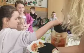 dziewczynka wrzuca warzywa do szatkownicy