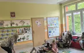 dzieci w rzędzie przed pochylającą się nauczycielką dzieci leżą