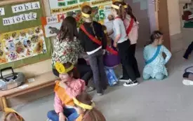 dziewczynki stoją przed tablicą na kt&oacute;rej powieszone są kolorowe zdania i obrazekłąki widać panią nauczycielkę obok