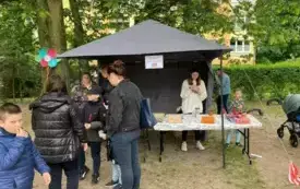 ludzie na pikniku w ogrodzie przedszkolnym w tle stoisko kiermasz książek