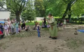 pan alchemik pokazuje coś chłopcu dookoła dzieci z innych grup