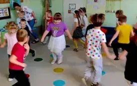 dzieci w ruchu na sali na podłodze leżą kolorowe krążki