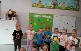 dzieci pozują do zdjęcia grupowego w tle dekoracja na dzień kropki