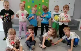dzieci pozują do zdjęcia grupowego w tle dekoracja na dzień kropki