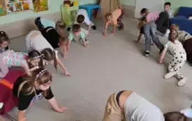 grupa dzieci w ruchu na dywanie w pozie na czworaka