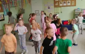 grupa dzieci stoi na całej sali zdjęcie w ruchu
