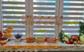 napis jesień zawieszony na oknie na parapecie leżą r&oacute;żne dary jesieni owoce warzywa grzyby kasztany