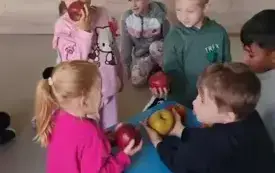dzieci oglądają dotykają wąchają jabłka na dywanie leżą r&oacute;żne obrazki jabłek