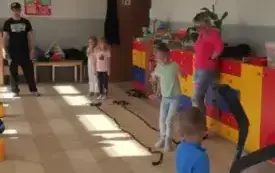 chłopiec trzyma kij do hokeja w tle dziewczynki pan i pani