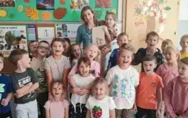 dzieci pozują do zdjęcia grupowego wraz z panią pielęgniarką