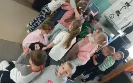dzieci przytulają się do pani część dzieci siedzi na dywanie