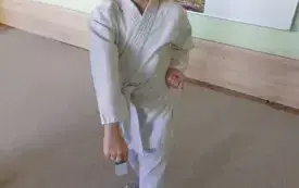 dziewczynka ubrana w kimono prezentuje pozę karate