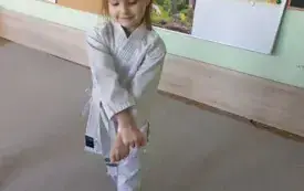 dziewczynka ubrana w kimono prezentuje pozę karate