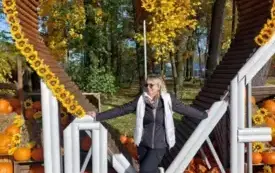 pani w słonecznych okularach na tle dekoracji w kształcie serca na ziemi leżą dynie napis love