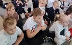 dzieci siedzą na dywanie