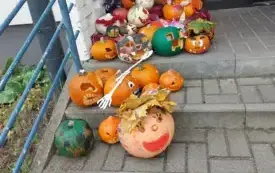 kolorowe udekorowane dynie leżą  na schodach i w wejściu do przedszkola 